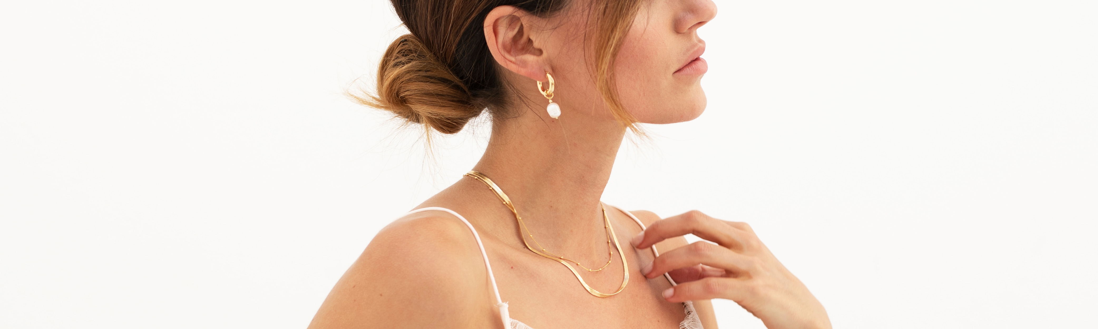 woman in wedding dress wearing a gold headband with pearls