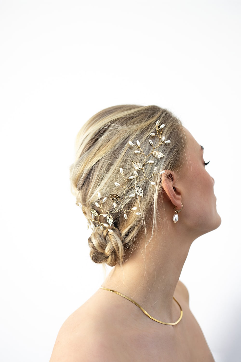 woman in wedding dress wearing a gold headband with pearls