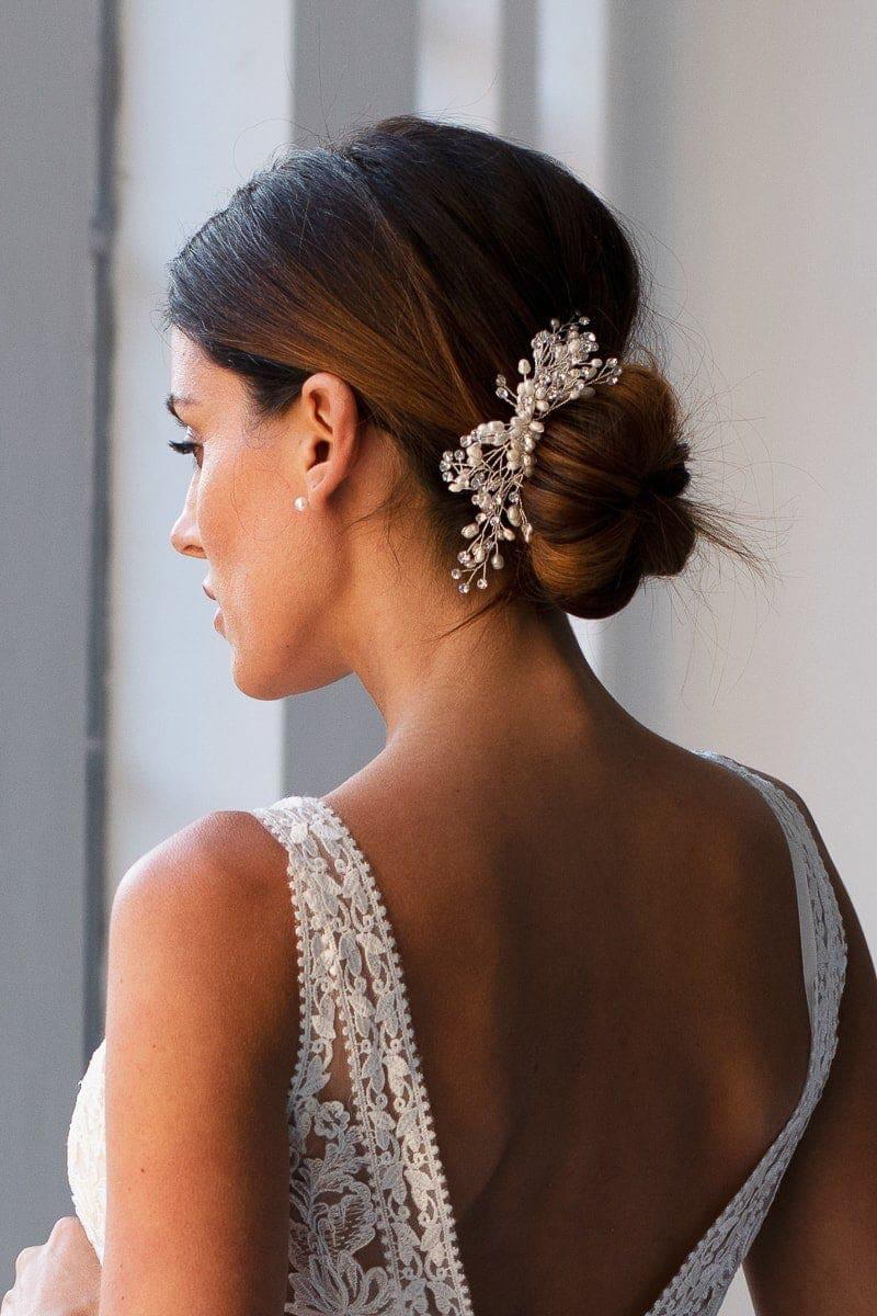 woman in wedding dress with a low bun and a hair comb with pearls
